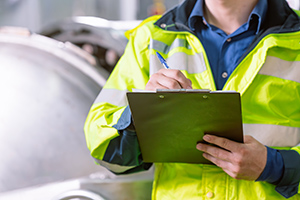 Engineer staff worker write note, checking routine working monitor factory plant with check board